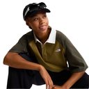 Person wearing a green and brown shirt with a logo, sitting on a white background
