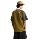 Person wearing a green and black shirt with a visible brand logo on a white background