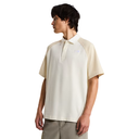 Person wearing a beige and white polo shirt on a white background