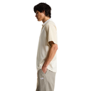 Person wearing a beige polo shirt and light gray pants on a white background