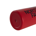 Close-up of a red cylindrical product, likely a tumbler or container, showing a matte red finish and black printed text reading 'THE NORTH FACE' on a white background.