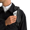 Person holding a phone in a black jacket with a white background