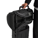 Person holding a black backpack over a black suitcase on a white background