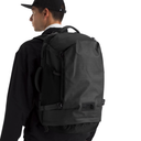 Person wearing a black backpack with a visible brand logo on a white background