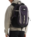 Person wearing a purple and black backpack with The North Face logo on a white background