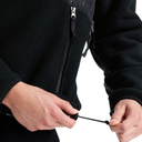 Close-up of a person wearing a black fleece zip jacket, pulling the drawstring of the front zipper.
