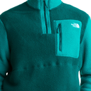 A close-up of a teal fleece pullover sweater by The North Face, featuring a quarter-zip collar, a vertical zippered chest pocket, and the brand's white logo on the pocket.