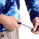 Close-up of a person wearing a blue and white tie-dye fleece pullover and beige pants, pulling the drawstring of the fleece.