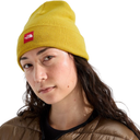 A woman wearing a yellow ribbed knit beanie with a red The North Face logo patch on the front, photographed against a clean white background.