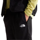 Black pants with The North Face logo worn by a person on a white background