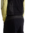 Close-up of a person wearing a black jacket with a yellow sleeve on a white background