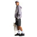 Person wearing a gray jacket, black shorts, and white sneakers with a white background