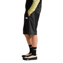 Person wearing black shorts with a brand logo on a white background