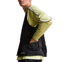 Person wearing a layered outfit with a black and yellow jacket on a white background
