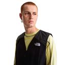 Person wearing a black The North Face vest over a light green shirt on a white background