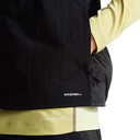 Person wearing a black jacket with 'Windwall' branding, over a layered outfit.