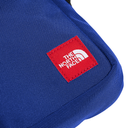 Close-up of a blue fabric pouch with a red square The North Face logo patch on the front, set against a plain white background.