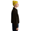 A man shown in profile wearing a dark brown Carhartt jacket, a bright yellow beanie, and blue jeans, photographed against a solid white background.