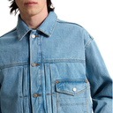 A close-up of a person wearing a light blue denim jacket, showing the collar, front buttons, chest pockets, and fabric texture against a plain white background.