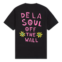 A black short-sleeve t-shirt shown from the back, featuring a colorful graphic print with the text 'DE LA SOUL OFF THE WALL' in pink, a peace sign, and two yellow daisies with green centers.