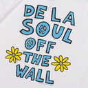 White t-shirt featuring a colorful graphic print with the text 'DE LA SOUL OFF THE WALL' in light blue with black outlines, decorated with peace signs and yellow daisies.