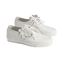 A pair of white low-top canvas sneakers with white laces and a white flower embellishment on the side, set against a plain white background.