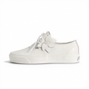 A white leather Vans platform sneaker featuring a decorative white fabric flower embellishment on the side, white laces, and a thick white rubber sole, shown against a plain white background.