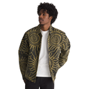 A man wearing a zip-up jacket with a bold olive green and tan spiral pattern, layered over a white t-shirt and black pants, set against a plain white background.