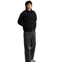 A model wearing a black textured zip-up jacket, dark gray wide-leg pants, and checkered sneakers, standing against a solid white background.