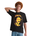 A model with curly orange hair wearing a black t-shirt with a yellow and pink graphic print of a face with sunglasses, paired with blue jeans, against a plain white background.