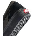 Close-up of a black shoe with a red and white logo on a white background