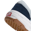 Close-up of a Vans shoe with a white sole, blue suede side panel, and brown sole.