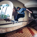 Person skateboarding on a ledge with a cityscape in the background