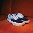 Pair of blue and white sneakers on a brown surface