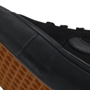 Close-up of a black Nike sneaker showing the textured black upper, black rubber sole, and a brown waffle-patterned outsole.