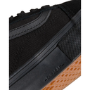 Close-up of a black sneaker with brown sole on a white background
