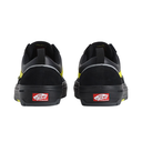 A pair of black Vans platform sneakers shown from the back, featuring bright yellow accents on the sides and a red Vans logo patch on the heel.