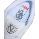 Close-up of a white Vans sneaker showing the inner side with a visible Vans logo on the tongue and a red Supreme box logo on the insole.