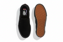 Black slip-on shoe with brown sole on a white background