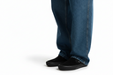 Blue jeans worn by a person on a white background