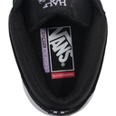 Close-up top view of a black Vans Half Cab sneaker showing the inner collar with the Vans logo patch, a purple 'Rough' tag, and a red 'Skateboarding' tag on a white background.