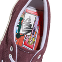 Close-up of a sneaker's tongue with colorful graphics and text, featuring the brand 'Vans'.