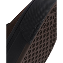 Close-up detail of a brown slip-on shoe showing the textured black outsole, a black heel pad with embossed branding, and the brown geometric patterned tread.