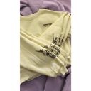 Light yellow sweatshirt with black graphics and text on a purple surface
