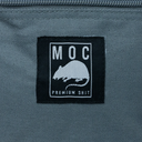Black label with 'MOC' and rat illustration on a gray fabric background
