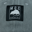 Label with 'MOC PREMIUM SHIT' text and logo on a gray fabric background