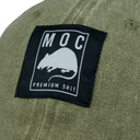 Green cap with a black patch featuring text and a logo on a white background