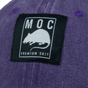 Close-up of a purple garment with a black label featuring text and a logo.