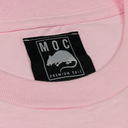 Close-up of a pink garment with a black label featuring text and graphics.